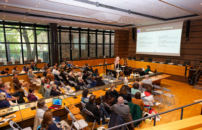 Tagungsraum mit Personen und Leinwand